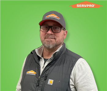 male employee wearing a white shirt with a black SERVPRO vest