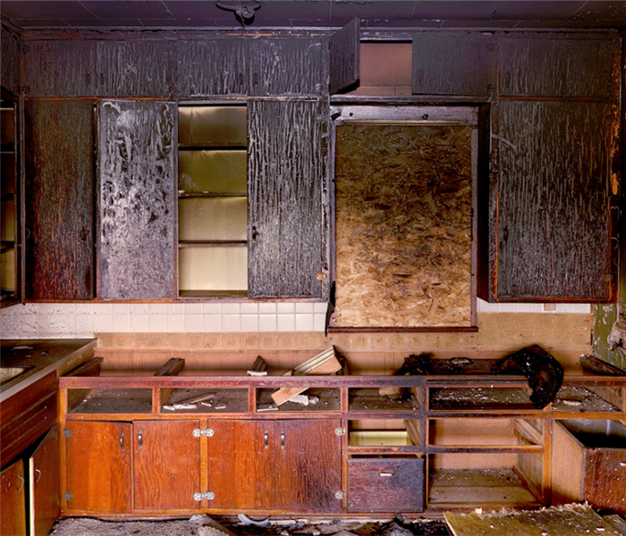 a fire damaged kitchen with soot covering the cabinets