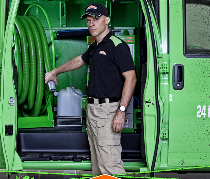 servpro tech standing by van with drying equipment